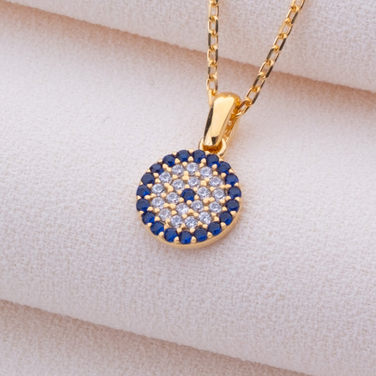 925 ayar gümüşten el yapımı nazar kolyesi. Negatif enerjiden koruduğuna inanılan nazar sembolü minimalist bir tasarımla sunulur. 14K altın, gümüş, rose gold veya siyah kaplama seçenekleri mevcuttur. İnce cable chain zincir, 2,5 cm uzatma halkası ve lobster clasp kilit ile tamamlanır. Günlük kullanım ve özel günler için ideal, hediye kutusunda sunulur.