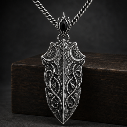 Oxidized 925 sterling silver pendant necklace with a blade-shaped relic pendant, crescent moon details, raised vine engraving, decorative bail and curb chain on a black background.