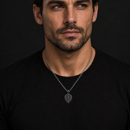 Oxidized 925 sterling silver pendant necklace with a phoenix crest, flame relief, shield outline, dark antique recesses and included curb chain on a black background.