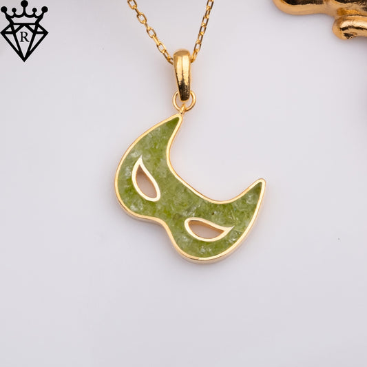 Close product image of the Gold Plated Silver peridot mask pendant suspended from its chain on a white background