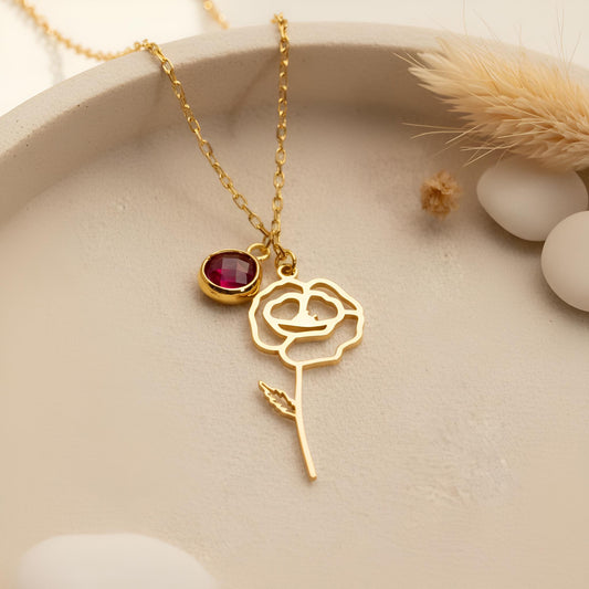 Close view of Gold Plated Silver floral pendant with long stem, leaf detail, and round red stone accent