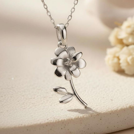 Silver Cosmos Flower Necklace close-up showing the textured center, curved stem, and two leaves