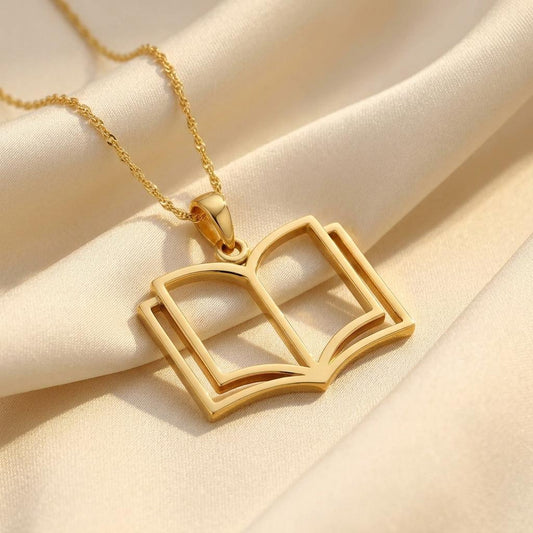 Gold Plated Silver openwork book pendant necklace on ivory satin fabric