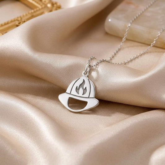 Firefighter helmet pendant necklace displayed on champagne satin fabric