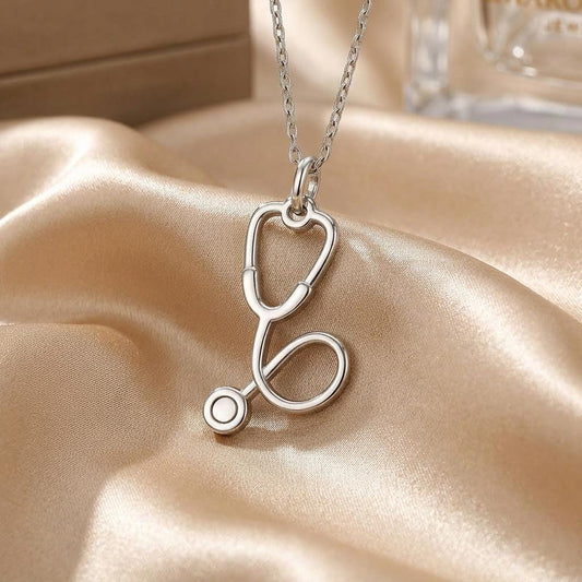 Close-up of the Stethoscope Charm Necklace on champagne-colored satin