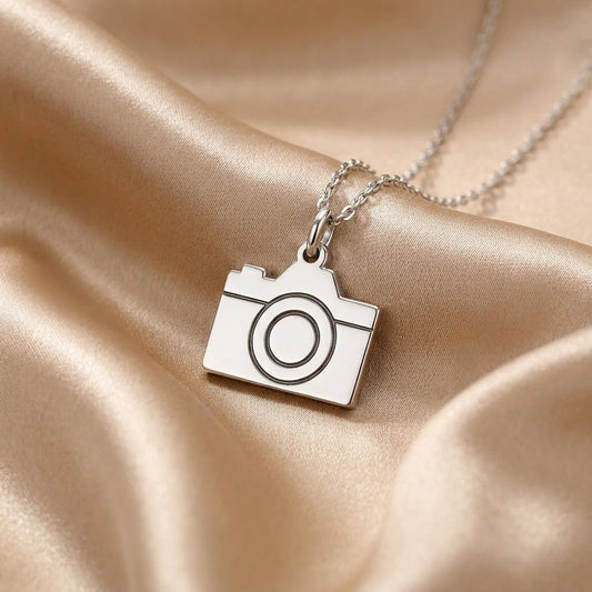 close-up of a 925 sterling silver camera pendant necklace on champagne satin