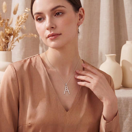 Model wearing the silver Architect Compass Necklace with a satin blouse