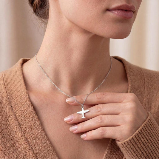 Model wearing the polished airplane pendant necklace with a knit top