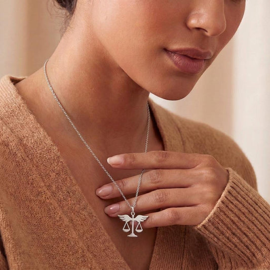 Justice Scales Necklace worn with a brown knit top