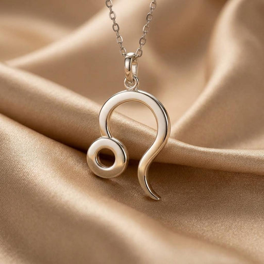 Silver looped pendant necklace displayed on champagne satin