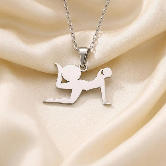 Close view of a yoga pose pendant with an extended forward leg on cream satin