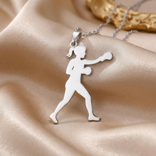 Close-up of the polished female boxer pendant with ponytail, rounded gloves, and forward punch on satin