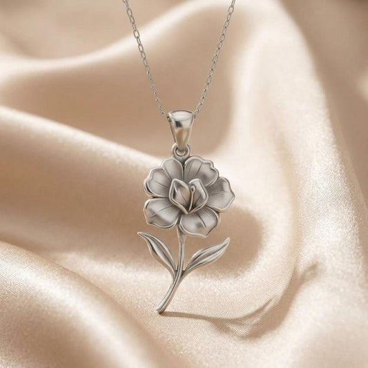 Silver gloxinia flower pendant necklace displayed on ivory satin